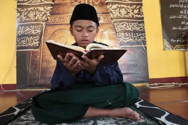 دپوک، اندونزی ـ دانش آموزی قبل از افطار در ماه مبارک رمضان در مدرسه شبانه روزی اسلامی قرآن می خواند.