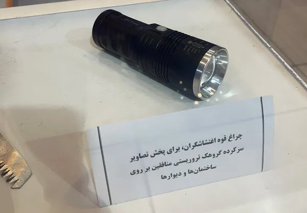 یکی دیگر از تجهیزات کشف&zwnj;شده چراغ قوه&zwnj;ای است که به وسیله آن تصاویر سران جنایتکار گروهک منافقین بر روی دیوارها و اماکن به نمایش درآمده است.