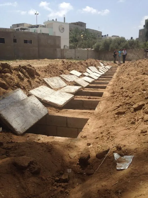 تصویر متعلق به گور یک خانواده فلسطینی  است که به دست سربازان ارتش اسرائیل قتل عام شده اند. نیروهای رژیم صهیونیستی، دست به کشتار وحشیانه&zwnj;ای علیه خانواده بطش زده و خانه آن&zwnj;ها را در منطقه شعف در شرق شهر غزه هدف قرار داده که به دنبال آن ۱۸ فلسطینی از این خانواده به شهادت رسیده و حدود ۵۰ تن دیگر زخمی شده&zwnj;اند./TABNAK
