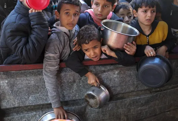 رفح، غزه ــ کودکان فلسطینی منتظر دریافت غذا از آشپزخانه خیریه هستند.