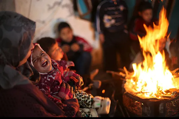 یک خانواده فلسطینی ساکن مخروبه های جنگ ۵۰ روزه اسرائیل خود را با آتش گرم می&zwnj;کنند.
