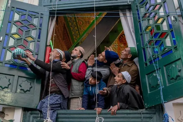 کشمیر، هند ــ مسلمانان کشمیری در حالی که کشیش یادگاری از قدیس صوفی شیخ سید عبدالقادر جیلانی را در خارج از زیارتگاهش در سرینگر به نمایش می گذارد، دعا می کنند.